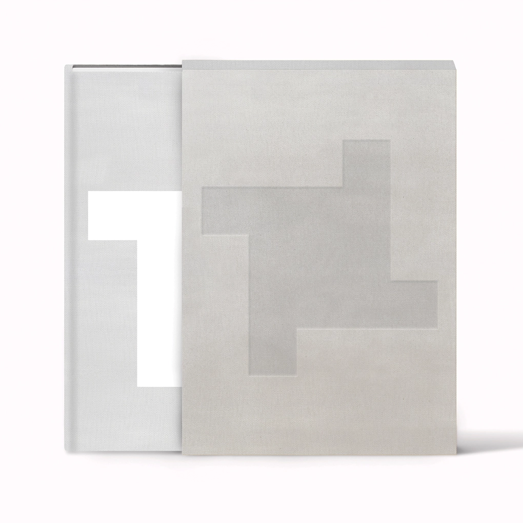 The hardback edition emerging from the slipcase, both in stylish grey.